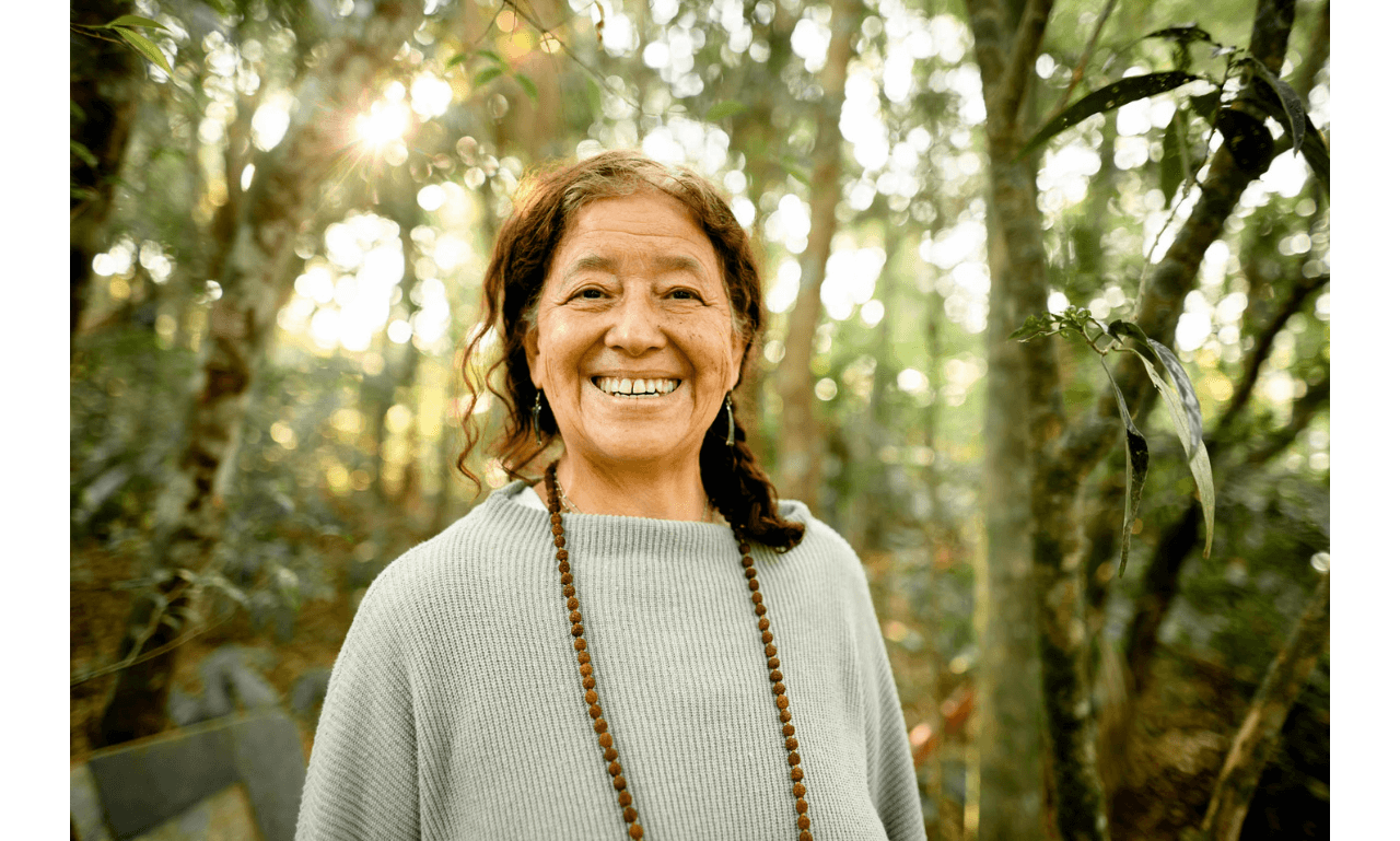 Laughing senior woman standing outside in her backyard in summer